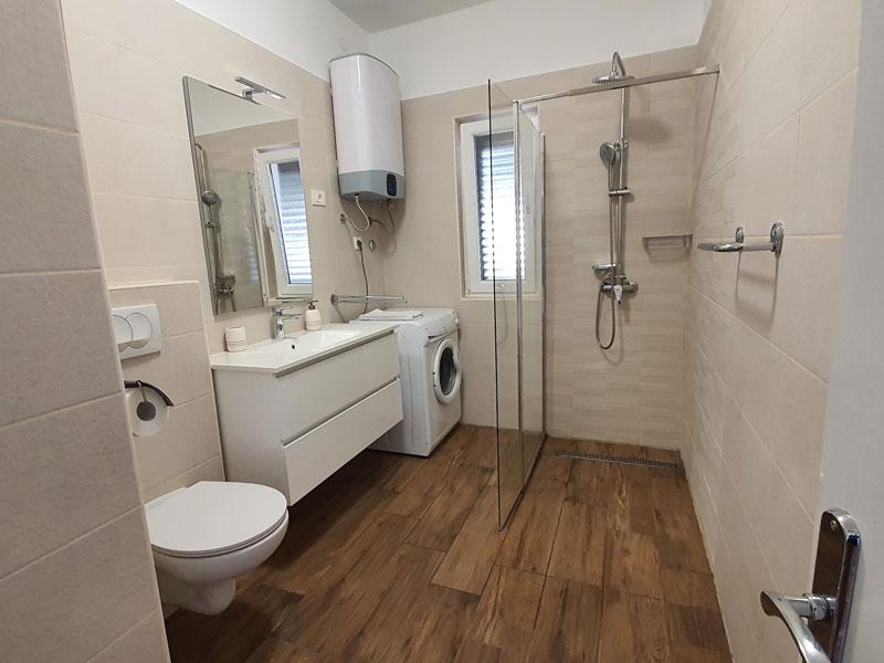 Bathroom with shower and washing machine in Apartment S1-A