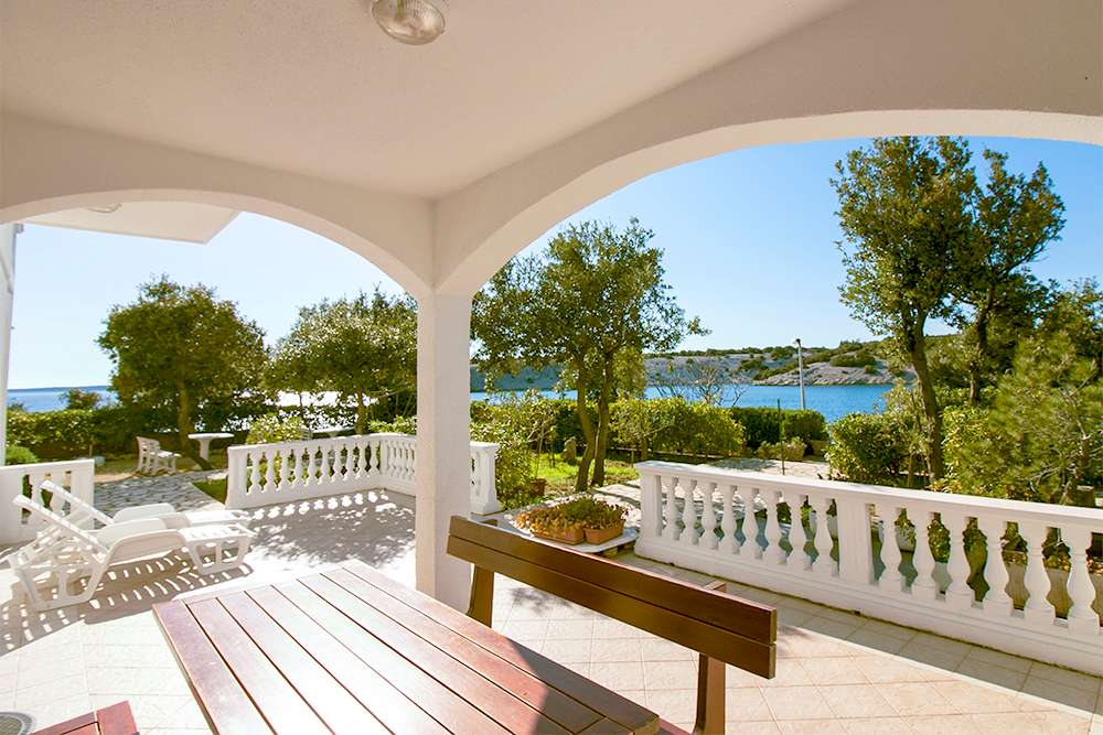 Large terrace of Apartment S1-A with table, chairs and direct sea view