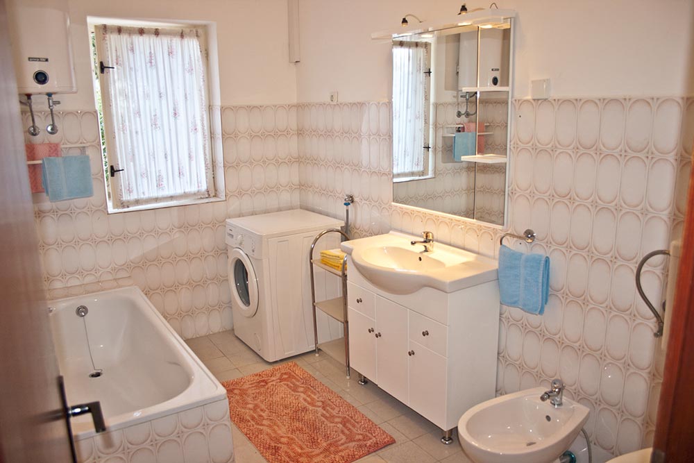 Bathroom with shower and washing machine in Apartment S1-B
